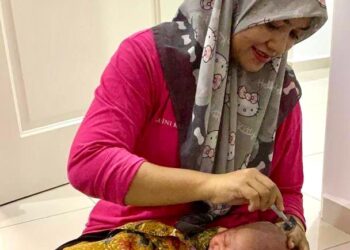 KASTINI Kasim mencukur rambut bayi salah seorang pelanggannya yang mendapatkan khidmat penjagaan wanita berpantang di Kangar, Perlis, baru-baru ini.