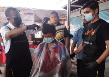 DR. NOOR  Azmi Ghazali (kanan) menggunting rambut pelajar dalam program Program Gunting Rambut Percuma di Giat Mara Bagan Serai, Bagan Serai. - UTUSAN/WAT KAMAL ABAS