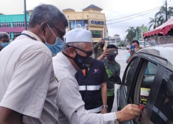 RAZMAN Zakaria mengedarkan risalah mengenai penyakit rabies kepada pemilik anjing pada Program Pemvaksinan Anti Rabies 2021 Daerah Larut Matang dan Selama di Kamunting, Perak. - UTUSAN/WAT KAMAL ABAS