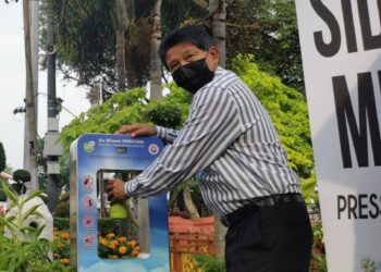 ZAINAL Abu mencuba mesin air minuman terawat percuma di hadapan bangunan Stadthuys, Melaka. - UTUSAN/DIYANATUL ATIQAH ZAKARYA