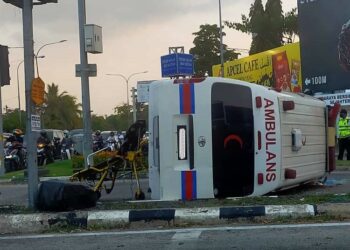 SEBUAH ambulans terbalik selepas terlibat dalam kemalangan di persimpangan lampu isyarat Plaza Tol Alor Setar Utara, Jalan Langgar, Alor Setar hari ini.