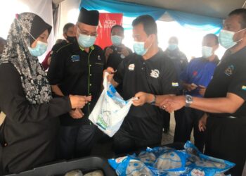 AZMAN Nasrudin (tiga dari kiri) menyampaikan ikan sejuk beku Q'Fish kepada pengunjung Program Jualan Prihatin Rakyat LKIM di Alor Setar, hari ini. - FOTO/NUR ANATI JUHARI