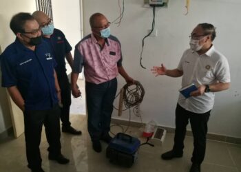 CHONG Fat Full (kanan) meninjau salah sebuah rumah penduduk yang menggunakan generator bagi mendapatkan bekalan elektrik ekoran ketiadaan kemudahan itu di sebuah flat di Taman Desa Kempas, Johor Bahru, Johor. -UTUSAN/MOHAMAD FAIZAL HASHIM