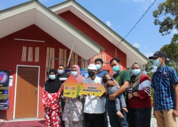 KHAMIS Jobok (tengah) dan ahli keluarganya ceria selepas memiliki kediaman baharu sempena Majlis Penyerahan Rumah untuk Projek Rintis Pembinaan Rumah Prototaip Penyelidikan berasaskan Bamboocrete di Kampung Sri Repah, Tampin hari ini. - UTUSAN/ NOR AINNA HAMZAH