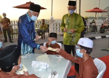 ABDUL Aziz Sheikh Abdul Kadir (kiri) bersama Dzarudin Che Omar (kanan) menyampaikan sumbangan duit raya kepada anak-anak yatim sempena Majlis Berbuka Puasa di Hotel Klana Beach Port Dickson, Port Dickson hari ini. - UTUSAN/ZAKKINA WATI AHMAD TARMIZI