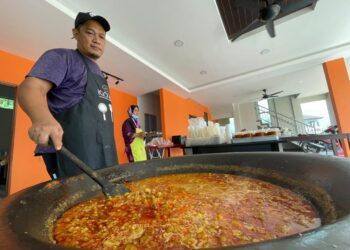 FAUZI Md. Zin atau Abe Uji memasak gulai kawah di jalan Bukit Gedombak-Gong Serapat, Pasir Puteh, Kelantan. - UTUSAN/TOREK SULONG