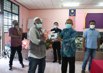 MOHD. Radzi Md. Amin (dua dari kanan) menyampaikan sumbangan kepada mangsa ribut di Dewan Petunas, Felda Lubuk Merbau, Padang Terap. - UTUSAN/SHAHIR NOORDIN