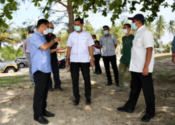 SHARUDIN Hamid (kiri) memperkatakan sesuatu kepada Abd. Rahim Muda (kanan) dan Hamdan Hussin (tengah) ketika mengadakan lawatan kebersihan jalan pantai serta persisiran pantai di Pantai Sepat di Kuantan, Pahang. - UTUSAN/ DIANA SURYA ABD WAHAB