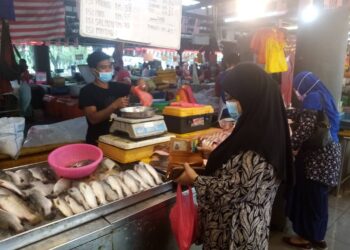 MUHAMMAD sedang menimbang ikan yang dimahukan pelanggannya di Pasar Moden Seksyen 6, Shah Alam, Selangor baru-baru ini.-UTUSAN/MOHAMAD NAUFAL MOHAMAD IDRIS