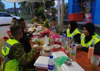 ZAINAH Awang Ngah (dua dari kanan) berbuka puasa dengan petugas barisan hadapan daripada pelbagai agensi di kawasan SJR Paya Berenjut di sempadan Terengganu-Pahang di Kemaman, baru-baru ini.