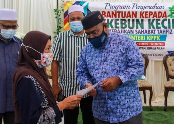 MOHD. Khairuddin Aman Razali menyampaikan bantuan pada majlis penyerahan sumbangan bantuan kepada golongan B40 pekebun kecil getah di Kuala Pilah semalam. - UTUSAN/MUHAMMAD IZZAT TERMIZIE