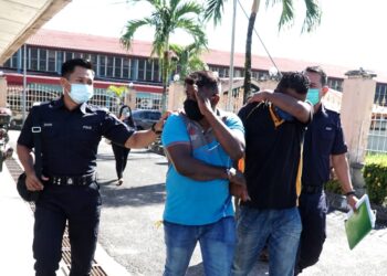 R. KUMARAN (depan kiri) dan B. Prasad Kumar (kanan) dibawa keluar dari mahkamah setelah mengaku bersalah membuat laporan polis palsu di Mahkamah Majistret Sungai Siput. - UTUSAN/ZULFACHRI ZULKIFLI