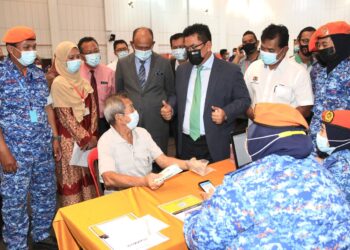 SULAIMAN Md. Ali (tiga dari kanan) diiringi Setiausaha Kerajaan Negeri, Datuk Seri Hasim Hasan (empat dari kiri) bersama Pengerusi Jawatankuasa Kesihatan dan Antidadah negeri, Datuk Rahmad Mariman (dua dari kanan) melawat warga emas iaitu pesara polis, Yun Ah Soon @ Ewe Ah Soon, 84, (tengah) yang telah menerima vaksin pada program Imunisasi Covid-19 Kebangsaan Daerah Melaka Tengah di Dewan Tun Ali Bukit Katil, Melaka. - UTUSAN/RASUL AZLI SAMAD