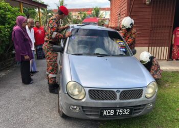 ANGGOTA bomba menjalankan operasi mengeluarkan kanak-kanak lelaki yang terperangkap dalam kereta di Kampung Bedrock di Tanjung Malim hari ini. - UTUSAN/IHSAN JBPM