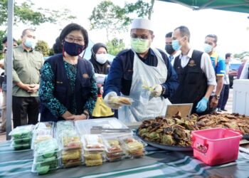 MOHD. Akmal Kamaruddin (tengah) mengambil sampel makanan dari sebuah gerai pada Majlis Pelancaran Operasi Keselamatan Makanan di Bazar Ramadan Dataran Orkid, Batu Gajah hari ini. - UTUSAN/ZULFACHRI ZULKIFLI