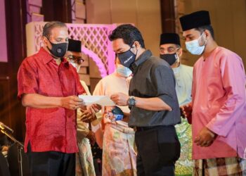 M. Saravanan (kiri) menyampaikan faedah caruman kepada salah seorang penerima sempena Majlis Iftar Perkeso di Kuala Lumpur. - UTUSAN/ MUHAMAD IQBAL ROSLI