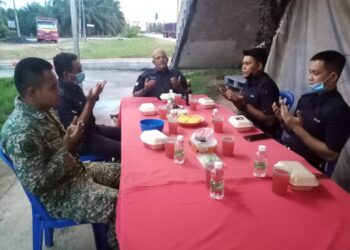 ALIFF (kanan) bersama anggota keselamatan yang bertugas di SJR Kilometer 33 Jalan Klang-Teluk Intan, Sabak Bernam, Selangor membaca doa sebelum berbuka puasa, semalam-UTUSAN/MOHAMAD NAUFAL MOHAMAD IDRIS