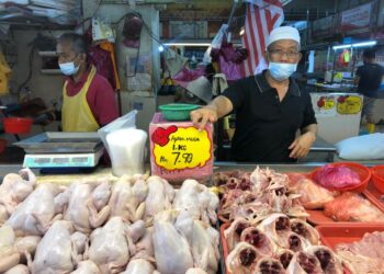 SHAHRAN Osman menunjukkan tanda harga baharu ayam standard yang dijualnya pada harga RM7.90 seperti ditetapkan di bawah SHMMP yang dikeluarkan KPDNHEP di Pasar Awam Larkin Sentral di Johor Bahru, Johor. -UTUSAN/MOHAMAD FAIZAL HASHIM