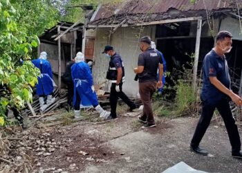 ANGGOTA polis memeriksa pondok tempat mayat seorang lelaki menggantung diri ditemukan di Bagan Sungai Burung, Bagan Datuk semalam. - IHSAN PDRM