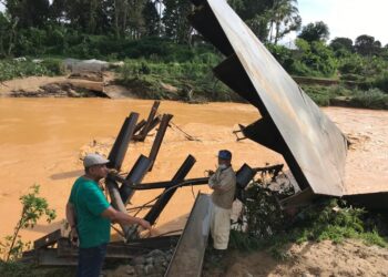 AB. Aziz Yusoff (kiri) meninjau jambatan yang dalam pembinaan dihanyut arus Sungai Galas di Kampung Batu Enam, Gua Musang, Kelantan, hari ini. - UTUSAN/AIMUNI TUAN LAH