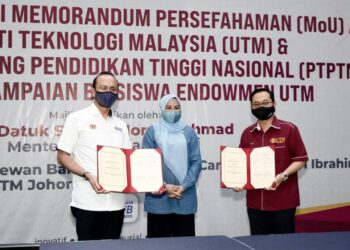 AHMAD Dasuki Abdul Majid dan Ahmad Fauzi Ismail menunjukkan dokumen memorandum persefahaman (MoU) PTPTN-UTM yang telah ditandatangani dan disaksikan oleh Noraini Ahmad.