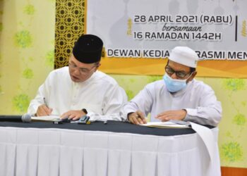 WAN Rosdy Wan Ismail (kiri) dan Rosli Abdul Jabar (kanan) menandatangani perjanjian MN Pahang di Dewan Kediaman Rasmi Menteri Besar di Kuantan, Pahang. - UTUSAN/SHAIKH AHMAD RAZIF