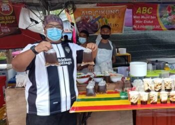 WAN Mohd. Ramzi Wan Jaafar menunjukkan air cikung yang laris dijual di gerainya di bazar Ramadan Cabang Tiga di Kuala Terengganu, semalam.