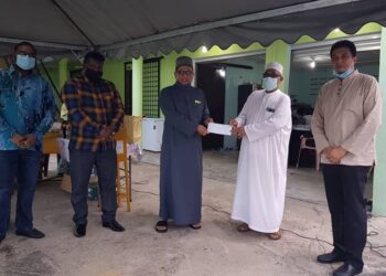 ZUHAIRI Ab. Kadir (tiga dari kanan) menyampaikan sumbangan Daz Bikers kepada Abdullah Kamil Ahmad (dua dari kanan) pada majlis berbuka puasa di Madrasah Tahfiz Kamaliah Litahfizil Banat, Gambang di Kuantan, Pahang.