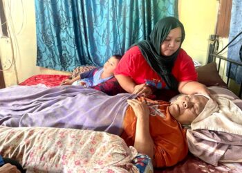 NOR Baiti menjaga ibunya yang terlantar akibat serangan strok seminggu sebelum Ramadan lalu di kediaman mereka di Kampung Guar Syed Alwi, Kangar, Perlis. - UTUSAN/NAZLINA NADZARI