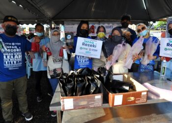 MUHAMMED Farhan Basheer (kiri) bersama para usahawan menunjukkan makanan dan minuman yang diberi secara percuma kepada orang ramai melibatkan sebanyak 2,021 pek sempena Ramadan di Larkin, Johor. -UTUSAN/RAJA JAAFAR ALI