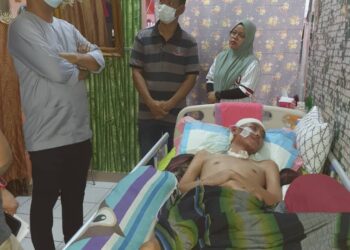 NORJANARIAH ABDUL HALIM memberi penjelasan kepada Hishamuddin Abdul Karim (kiri, bersongkok) mengenai keadaan suaminya, Amirul Hayat Noor Azman yang terlantar sakit di Taman Dato’ Tamby Chik Ramli, Melaka, semalam.