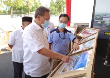 HASNI Mohammad (kiri) mendengar taklimat berhubung projek United Kotak Berhad sempena Majlis Pecah Tanah United Kotak Berhad 2, di Kulai, Johor. -UTUSAN/KHAIRUL MOHD ALI