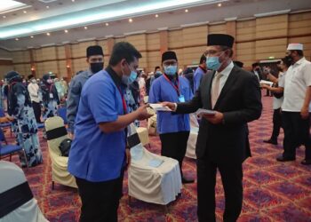 WAN Rosdy Wan Ismail (kanan) menyampaikan Bantuan Prihatin Pahang (BPP) kepada guru-guru Takmir dan KAFA di majlis penyerahan yang diadakan di Dewan Jubli Perak Sultan Ahmad Shah di Kuantan, Pahang. - UTUSAN/ DIANA SURYA ABD WAHAB