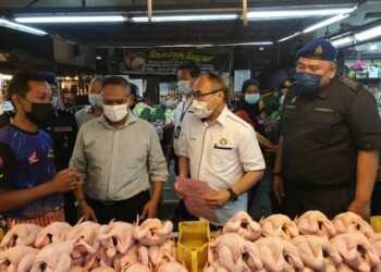 CHONG Fat Full (dua kanan) mendengar penerangan seorang peniaga ayam ketika membuat pemeriksaan bersama KPDNHEP Johor di Pasar Borong Pandan di Johor Bahru, Johor. -UTUSAN/MOHAMAD FAIZAL HASHIM