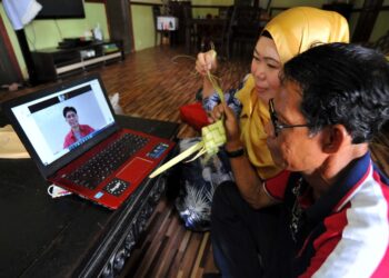 MEGAT Muhammad Fahmee Epindi yang berada di Seoul, Korea Selatan membuat panggilan video bersama ibu bapanya, Raja Kamariah Ali dan Epindi Husin di Kampung Melayu Majidee di Johor. -UTUSAN/RAJA JAAFAR ALI