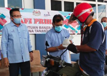 CHE Abdullah (dua kiri) menyerahkan sumbangan secara pandu lalu kepada seorang penerima di PPK Kubang Sepat, Tendong hari ini. - UTUSAN/YATIMIN ABDULLAH