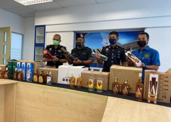 ROZASIN Ramlan (dua, kiri) menunjukkan antara minuman keras dirampas dalam serbuan di sebuah stor syarikat arak di Taman Cahaya Baru, Yong Peng, pada sidang akhbar di Batu Pahat, Johor. -UTUSAN/NUR ALINA HASSAN