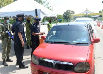 MOHD. Roze Shaari memeriksa dokumen seorang pemandu ketika mengadakan pemantauan di SJR Plaza Tol Alor Setar Utara, Alor Setar, hari ini. - UTUSAN/MOHD. RAFIE AZIMI