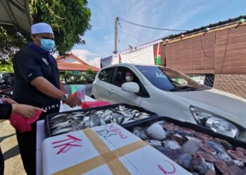 MOHD. Zatullah Kamaruddin menyediakan ikan yang ditempah oleh pelanggan di hadapan Pusat Jagaan Anak-Anak Yatim Walidaina, Taman Satria, Senawang, Seremban.- UTUSAN/AFIFI HAFIZ MOHD. NOR