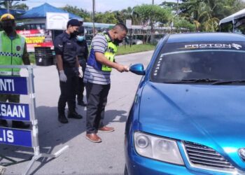 OSMAN Mamat memeriksa dokumen perjalanan pemilik kenderaan ketika meninjau SJR Taman Berkat di Taiping hari ini. - UTUSAN/WAT KAMAL ABAS