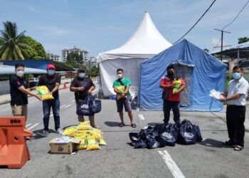 OH Tong Keong (kiri) menyerahkan bantuan makanan kepada wakil penduduk yang terlibat PKPD di kawasan Bayan Lepas, Pulau Pinang.