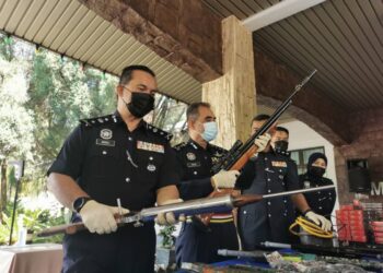 ABDUL Majid Mohd. Ali (dua dari kiri) memegang selaras senapang tiruan menyerupai senjata api yang dirampas pihak polis di Jasin, Melaka. - UTUSAN/DIYANATUL ATIQAH ZAKARYA