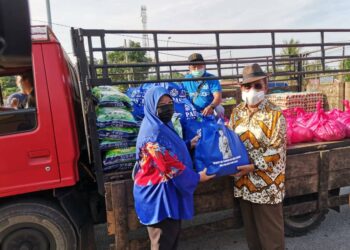 TAJUDDIN Abdul Rahman (kanan) menyampaikan sumbangan kepada penduduk di Chenderong Balai dekat Pasir Salak hari ini. - UTUSAN/AIN SAFRE BIDIN