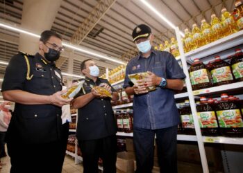 ROSOL Wahid (kanan) membuat pemeriksaan minyak masak di sebuah pasar raya di Teluk Intan hari ini.