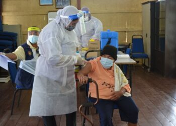 PENDUDUK Orang Asli, Bubot Tahad menerima suntikan vaksin sempena sempena Program Outreach Penerangan dan Pemberian Vaksin Covid-19 di Kampung Orang Asli Bukit Kepong, Port Dickson. - UTUSAN/ZAKKINA WATI AHMAD TARMZI