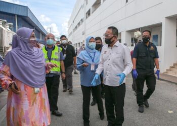 AWANG Hashim (kanan) yang mengetuai Operasi Pematuhan Akta 446 dan Prosedur Operasi Standard Akta 342 bertanyakan sesuatu kepada pekerja di sebuah kilang produk kesihatan di  Jitra, Kubang Pasu. - UTUSAN/SHAHIR NORDIN