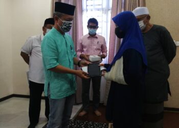 RAZALI Idris menghadiahkan tablet kepada Damia Irdina Mohd. Zuki, satu-satunya mangsa yang terselamat dalam kemalangan bersama ahli keluarganya ketika ditemui di rumahnya di Bandar Al Muktafi Billah Shah (AMBS) di Dungun sini hari ini.