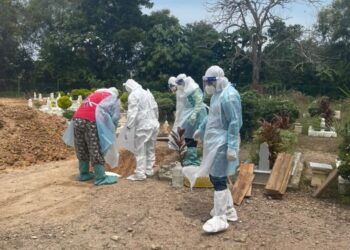 AHLI Crew Tanah Kubur Ijok memakai Pakaian Perlindungan Diri (PPE) sebelum memulakan proses pengebumian jenazah mangsa Covid-19 di Tanah Perkuburan Islam Kampung Ijok, Kuala Selangor. - UTUSAN / ABDUL RAZAK IDRIS