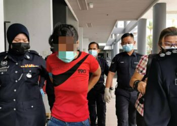 TERTUDUH dibawa keluar oleh anggota polis selepas didakwa dengan dua pertuduhan di Mahkamah Sesyen, Ayer Keroh, Melaka. - UTUSAN/DIYANATUL ATIQAH ZAKARYA