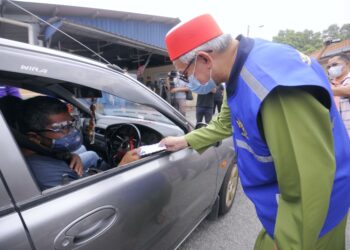 ZULKIFLI Mohamad Al-Bakri menyerahkan sumbangan kepada keluarga pekerja pembersihan dan pekerja kantin di daerah ini terjejas pendapatan pada program yang diadakan di Masjid Dato Haji Abdullah Sijang, Port Dickson, hari ini.-UTUSAN/MOHD. SHAHJEHAN MAAMIN.